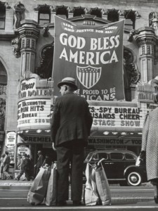 bob-landry-man-with-shopping-bags-in-front-of-million-dollar-theatre-emblazoned-with-god-bless-america-banner