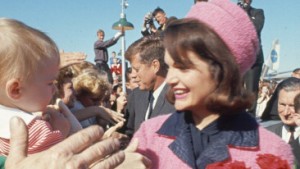 With a bouquet of roses in her hand, First Lady Jacqueline Kennedy (1929 - 1994) and, behind her, US President John F. Kennedy (1917 - 1963), greet the public at Love Field airport during a campaign tour, Dallas, Texas, November 22, 1963. The President was assassinated later that day. (Photo by Art Rickerby/Time & Life Pictures/Getty Images)
